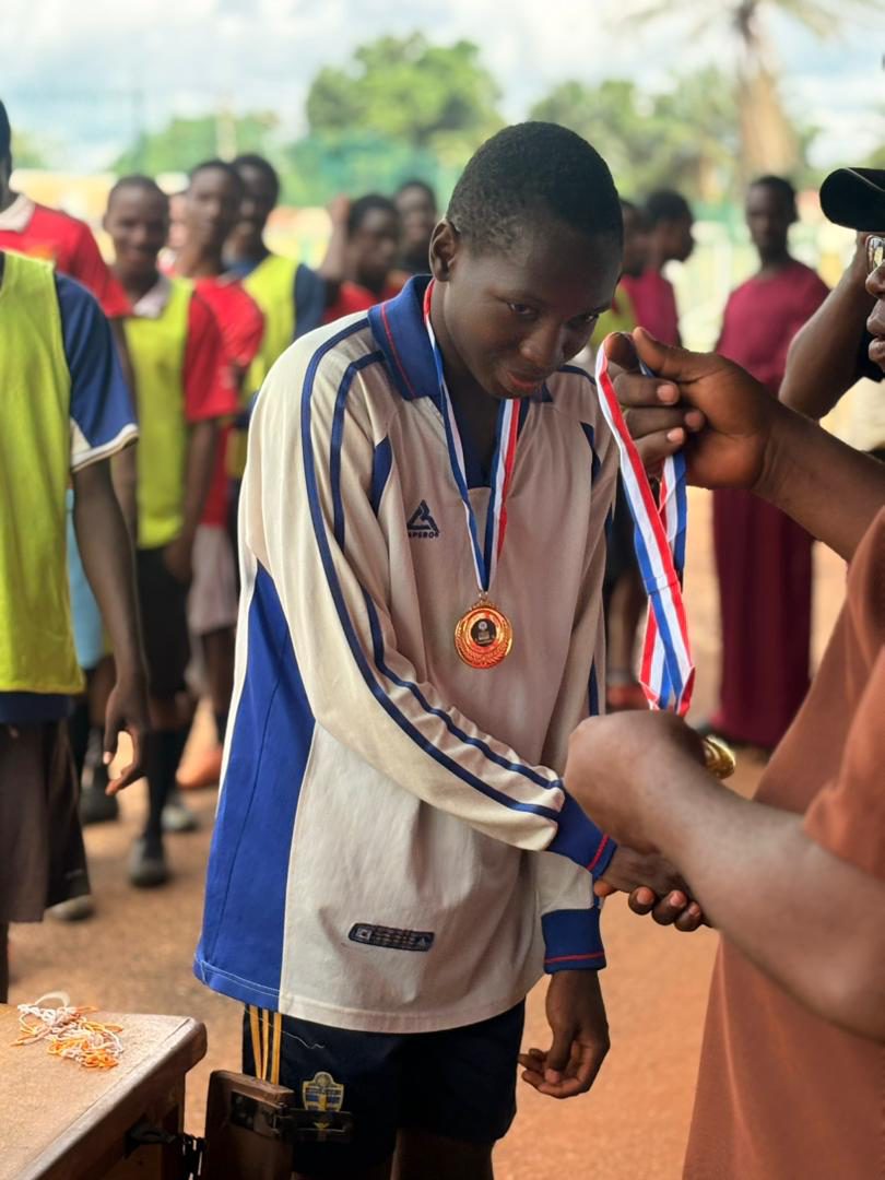Samuel receiving a gold medal after a football competition